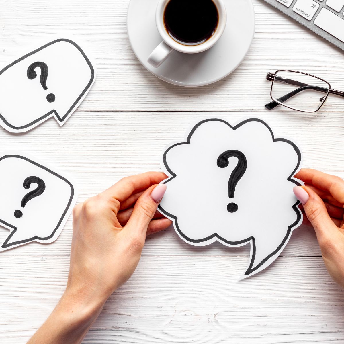 Hands holding question mark thought bubbles - representing curiosity and learning